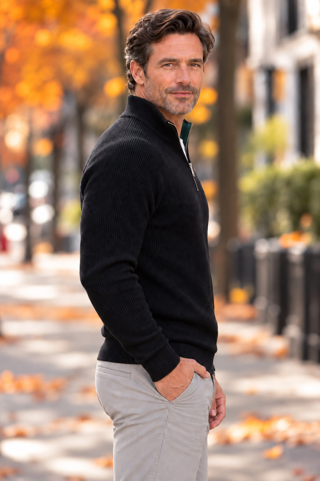 Side view of a man in a black half-zip knit sweater