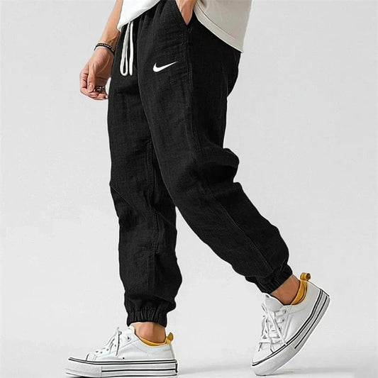 Men's black linen-look jogger pants with elastic drawstring waist, side pockets and cuffed ankles – side view