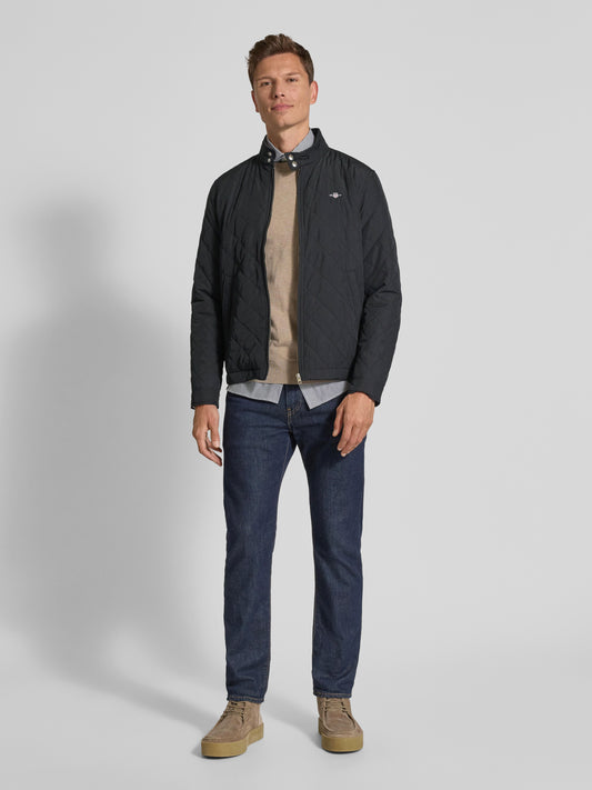 Men's black diamond quilted jacket with stand collar – full-length outfit with jeans and suede boots